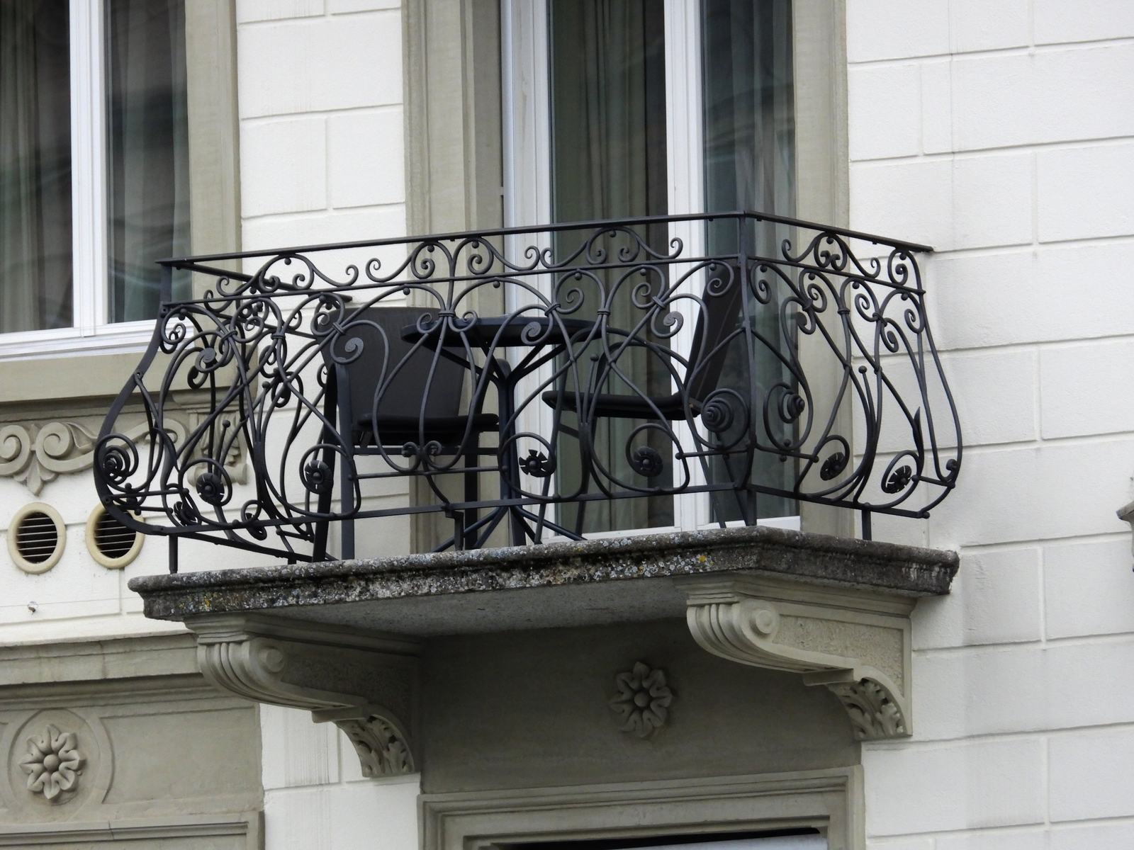 Schmiedeeiserner Jugendstil-Balkon an einer hellen Altbaufassade